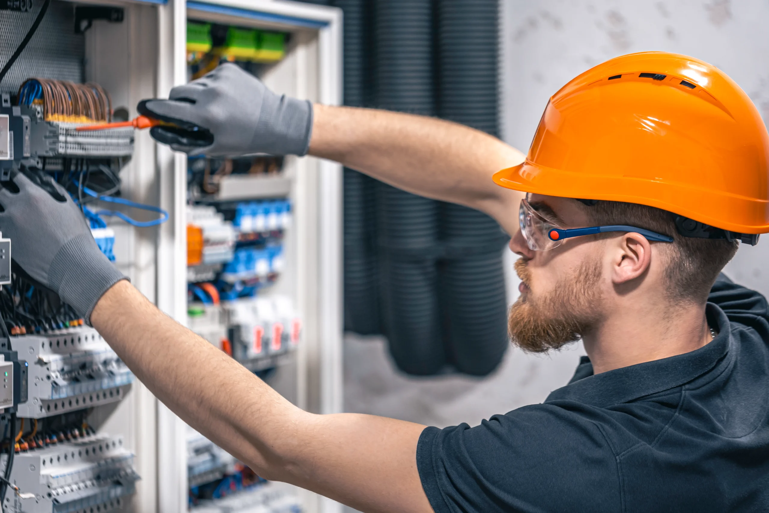 Electrician working on a switchboard for MEP estimating