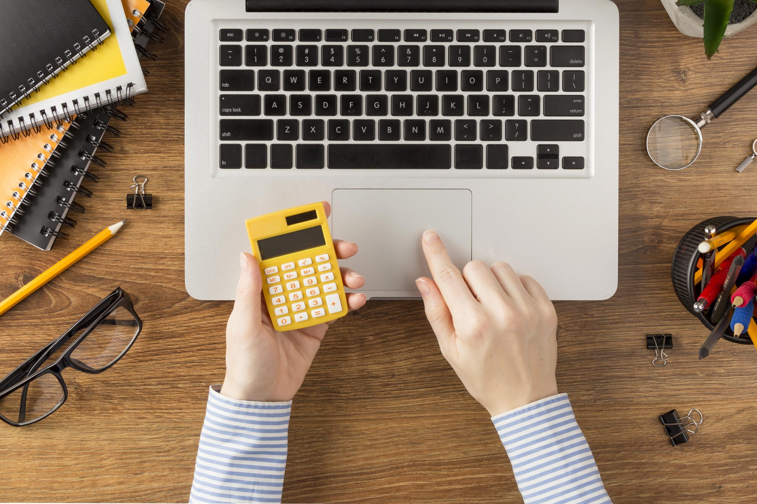 top-view-student-holding-calculator Estimator calculating construction costs